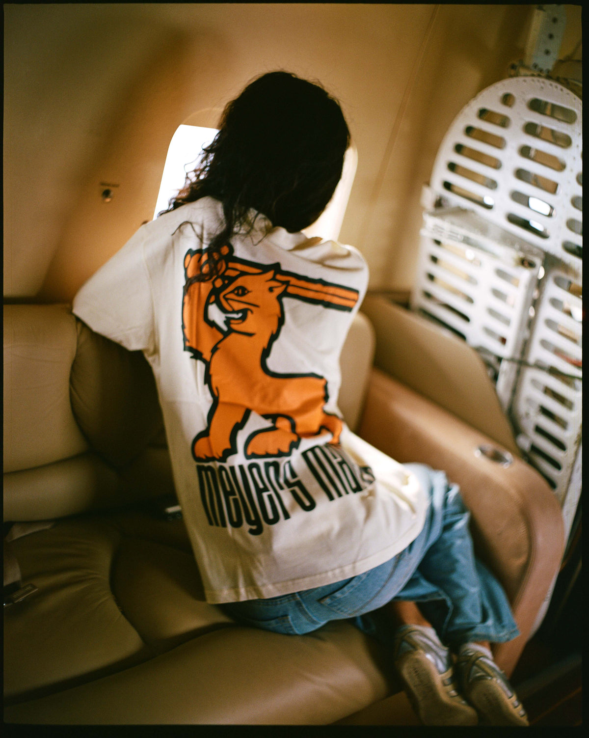 The back print of the cream Manx tee in a cabin seat