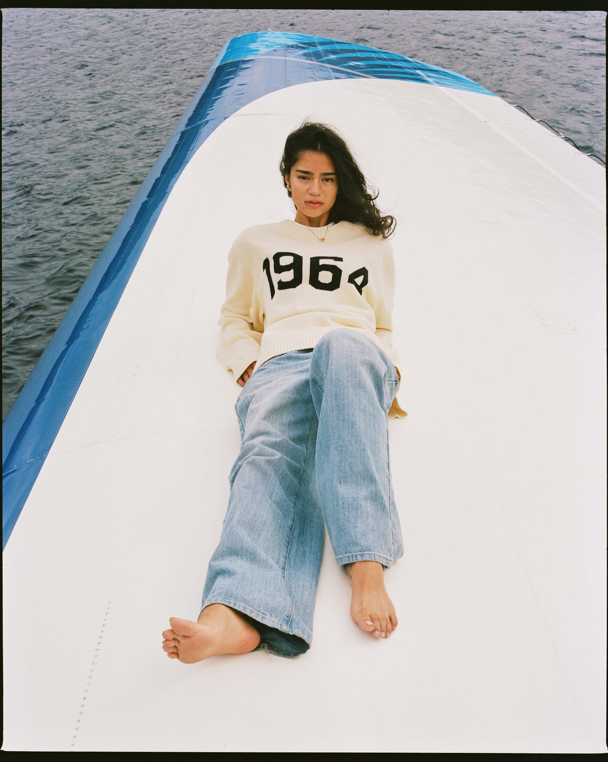 A woman in the cream 1964 sweater lying on the Albatross wing
